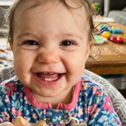 A baby laughing at the kitchen table