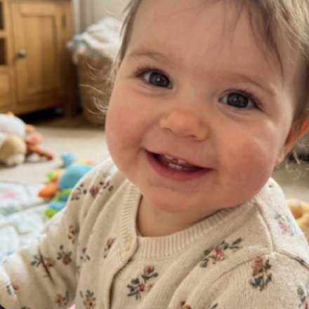The same baby smiling in the living room