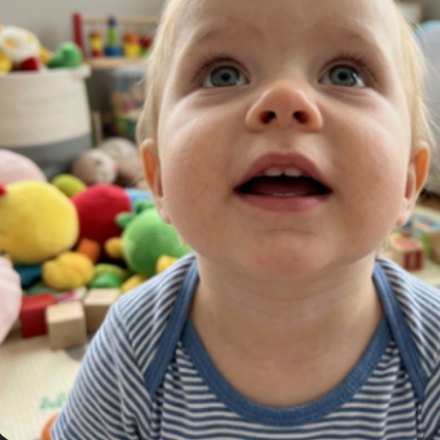 The same child looking up, surrounded by toys